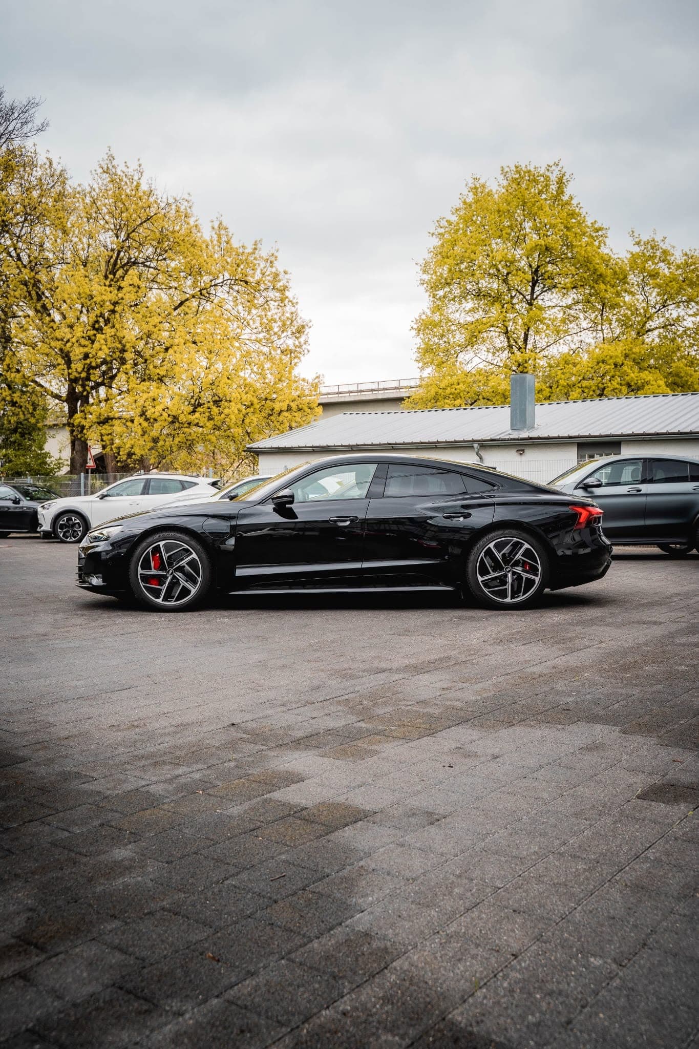 Audi e-tron GT in Schwarz, Seitenprofil auf dem Hof von Arnold Automobile